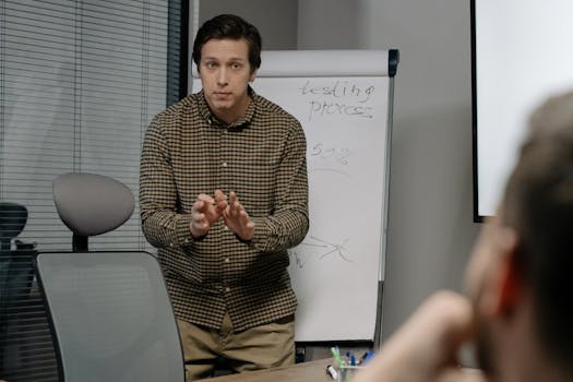 A man discusses testing processes during an office meeting with a focus on growth and strategy.